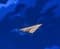 Tiny paper plane above the bridge outside the window