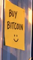 BUY BITCOIN. The yellow note is a deliberate callback to card 039 and its handwritten sign. It is not claimed to have appeared in the real office.