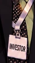 THE INVESTOR LANYARD. The badge makes Matos's role explicit: investor and viral speaker. It is an illustrative label, not a reproduction of an authenticated event badge. BitConnect's founder was Satish Kumbhani.