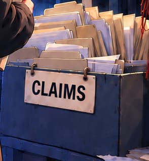 THE CLAIMS BOX. The files stand for affected clients seeking recovery. They are invented props, not copies of actual claim forms. The figure holding a folder is a fictional adult, not an identified claimant.
