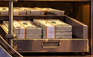 THE CASH TRAY. Notes remain in the lower drawer, keeping cash visible beside the new reserve asset. The image avoids an all-cash-converted claim; it does not quantify a remaining cash balance.