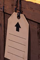 THE UNADDRESSED TAG. The right-hand crate carries a blank shipping tag and an upward handling arrow. Together with the packed machine, they suggest equipment in transit and the work of relocation. No destination or departure date is written into this imagined shipment.