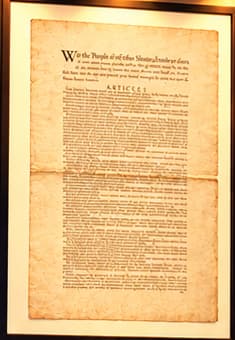 THE PRINTED CONSTITUTION. The tall framed paper sheet recalls the first printing of the Constitution's final text. Its dense single-column layout distinguishes the printed document being auctioned from the familiar handwritten original. The illustration is not a facsimile.