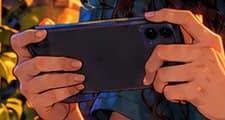 THE MOBILE SESSION. The player holds a phone sideways with both hands, its screen facing her. Axie's early application supported mobile play. Here the gesture emphasises attention and participation; no visible game interface, balance or earnings are claimed.