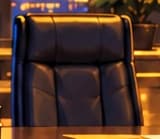 The empty executive chair. The vacant chair symbolizes Zhao's resignation as CEO. It marks a change in leadership, rather than Binance's disappearance. The chairs and office are invented storytelling details.