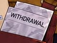 The old withdrawal paper. The worn sheet beside the envelope still reads WITHDRAWAL. It keeps the original problem beside the new correspondence, linking this scene to the customer's earlier wait.