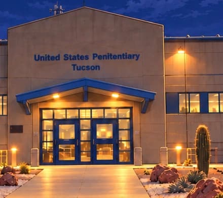 The Tucson entrance. The blue canopy, tan facade and prison name identify USP Tucson, where Ulbricht was held. Desert planting places the building in its Arizona setting.